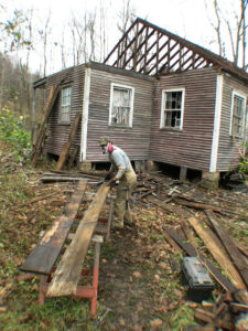 Gabe denailing and cleaning salvaged boards in Minden, West Virginia