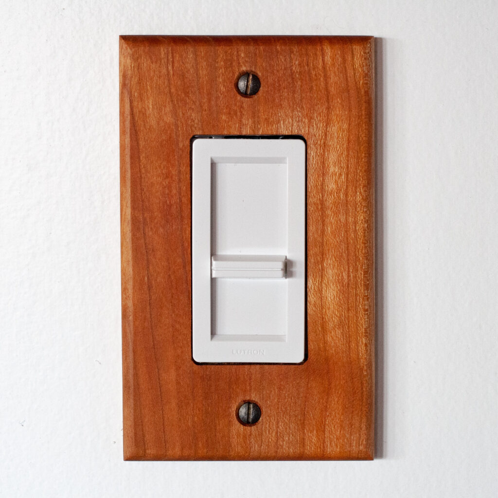 Lutron dimmer switch with a cherry wood outlet cover